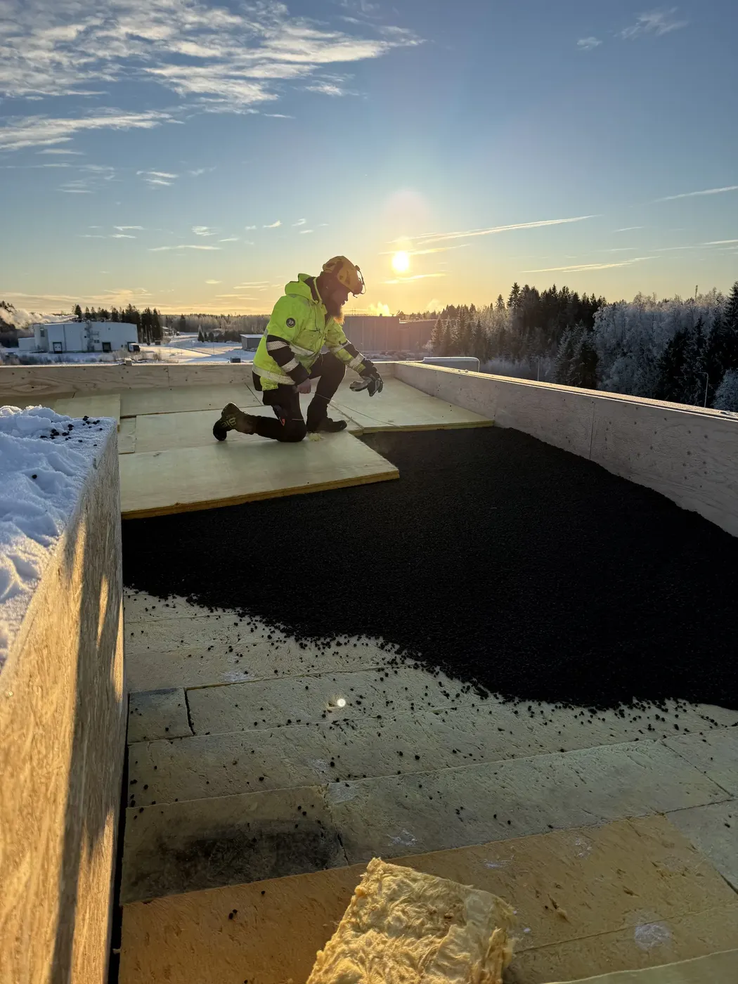 HuopaKuningas takläggare arbetar på ett bitumentak på vintern